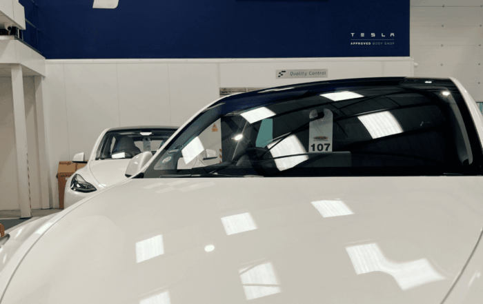 The image shows a white Tesla at Finesse approved body shop